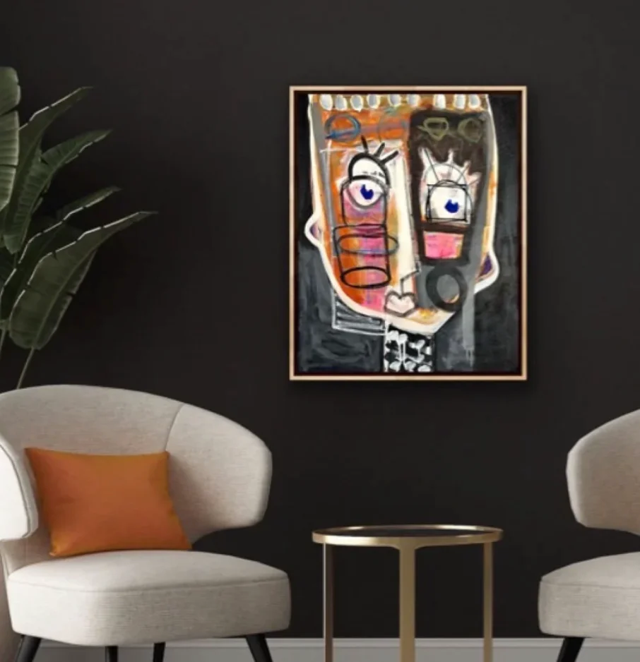 A dark black and orange abstract portrait painting hangs in a contemporary living room.